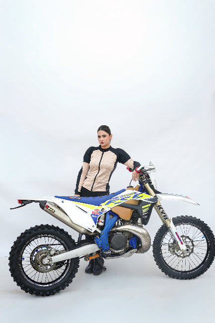 Person standing next to a dirt bike on a white background