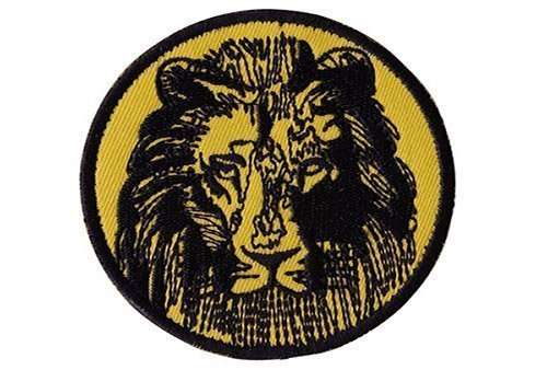 A close-up of a yellow and black embroidered biker patch featuring a lion graphic and stitching