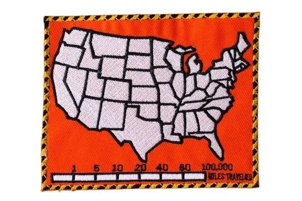 Front view of an orange embroidered biker patch featuring a white US map graphic and stitching