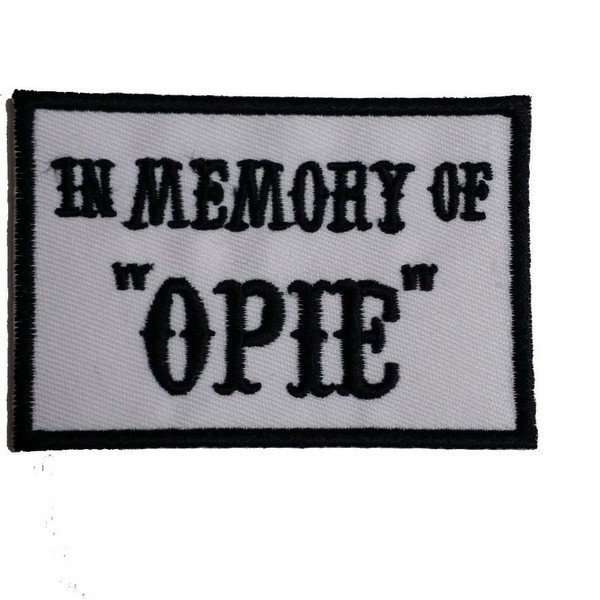 A black and white embroidered biker patch features stitched text