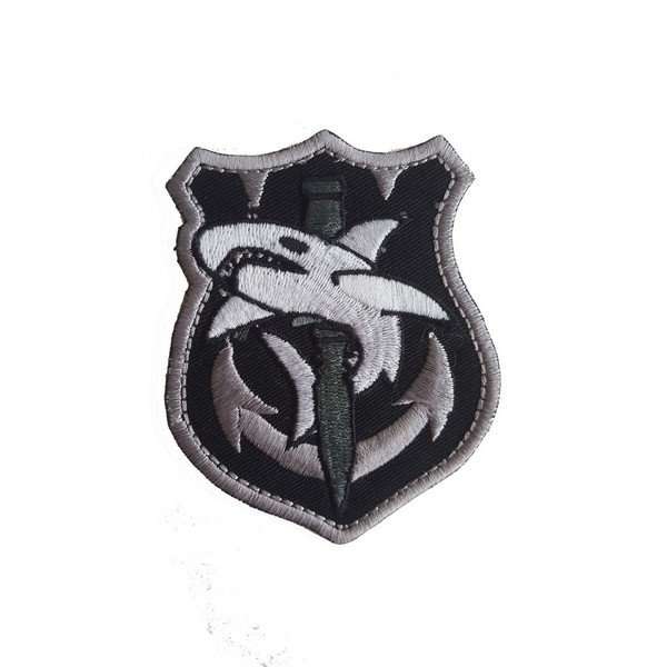 Front view of a black embroidered biker patch with grey stitching and white shark graphic