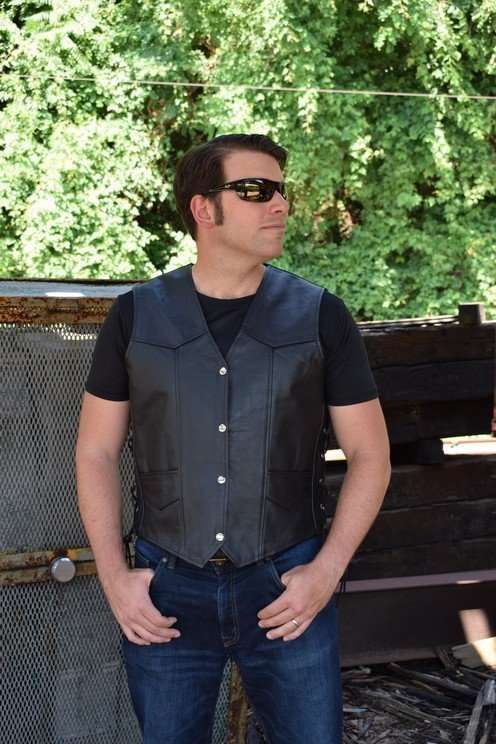 A model wears a black cowhide leather motorcycle vest with front snaps and pockets