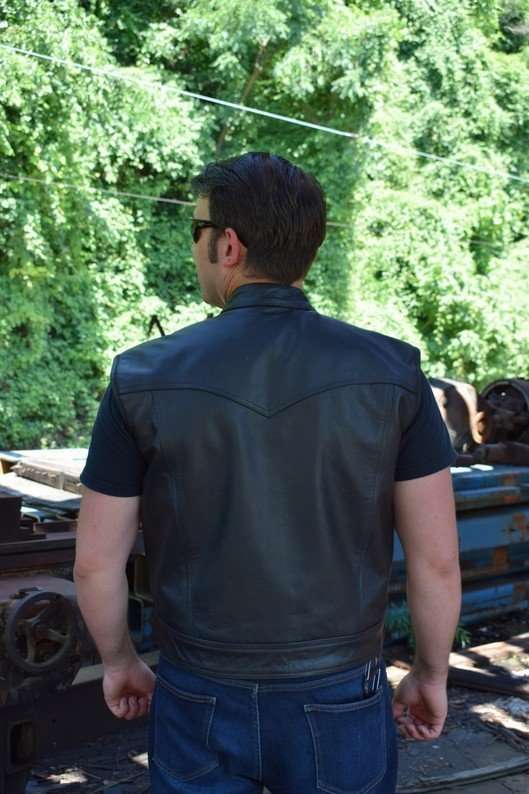 Back view of a black cowhide leather motorcycle vest worn by a model with panels